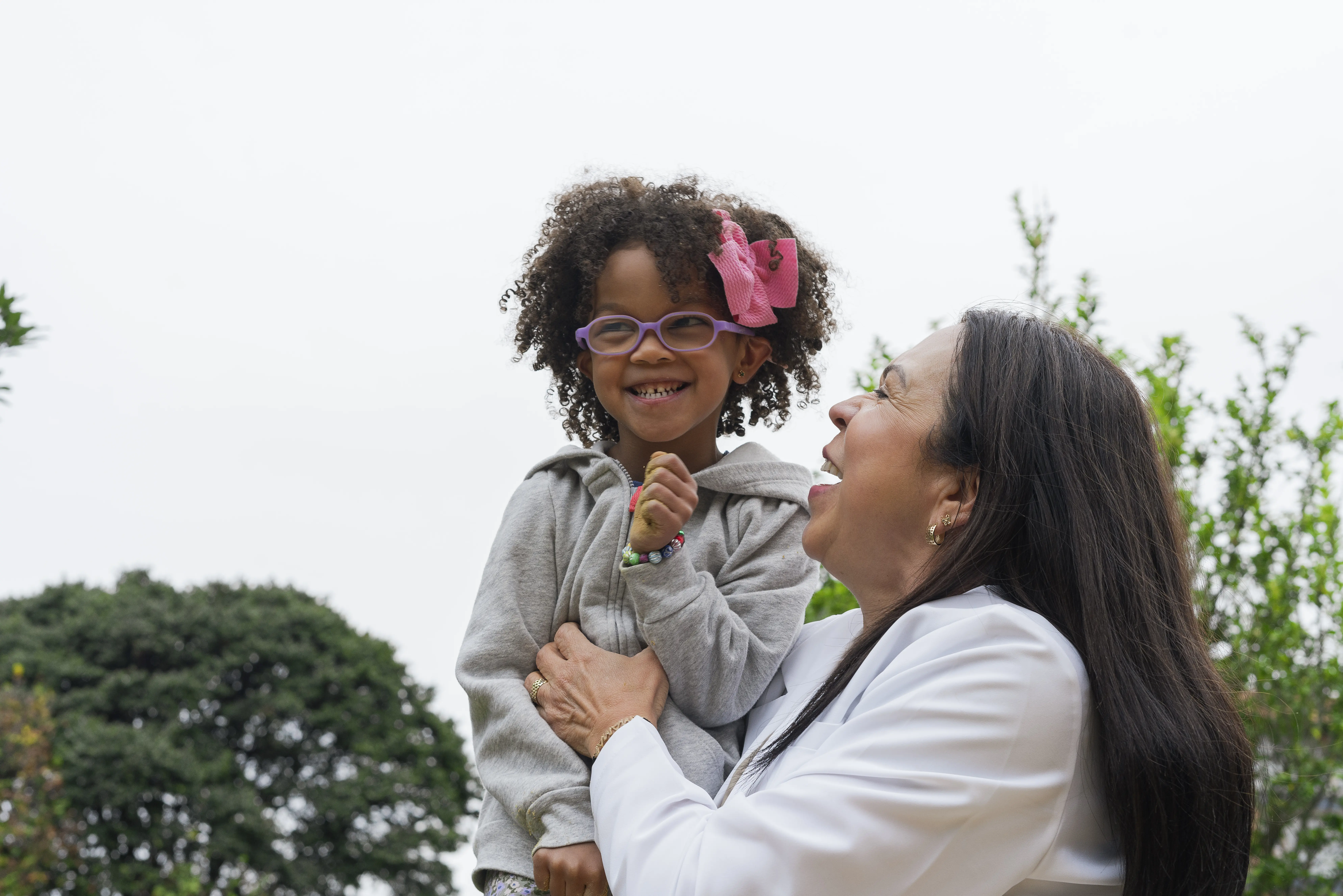 Physiotherapist pediatrician doctor doing exercises with her baby patient in the park sandbox Healthy Families America