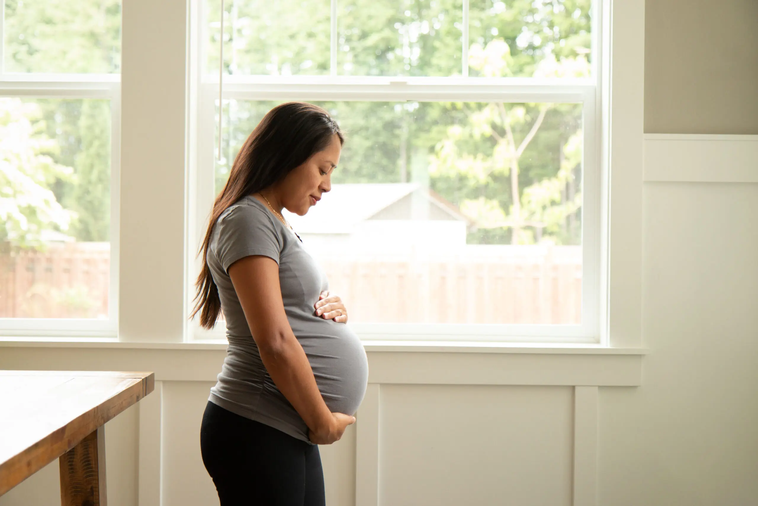 Young pregnant hispanic woman looking at her belly Healthy Families America