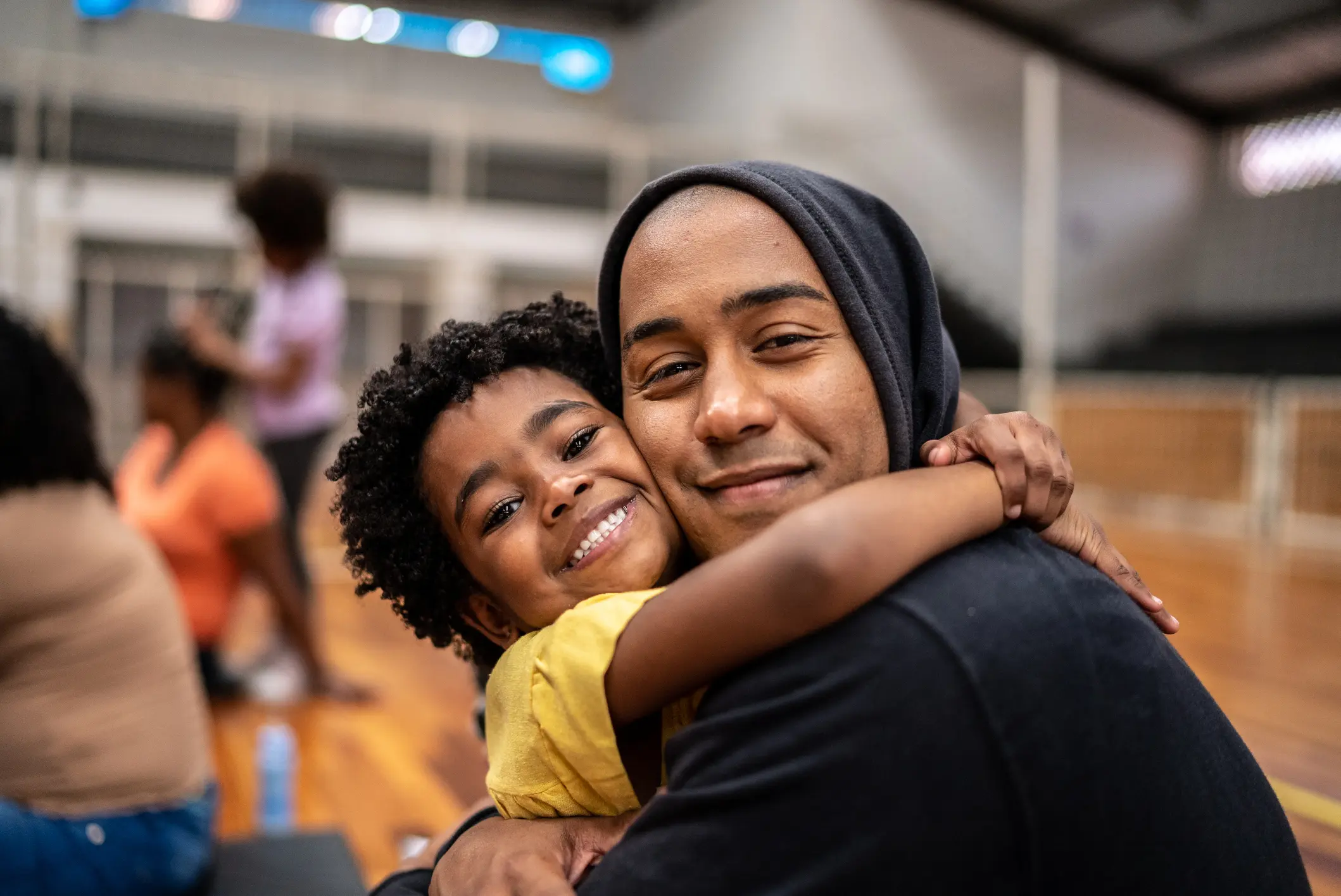 Portrait of father and daughter embracing at a community center Healthy Families America